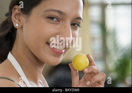 Frau hält eine Zitrone und lächelnd Stockfoto