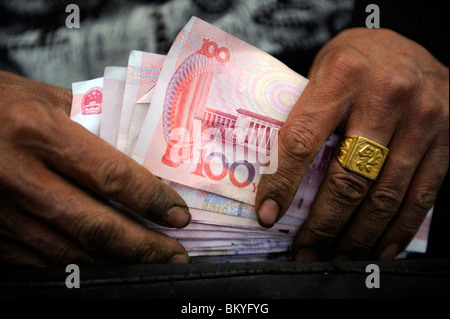 Ein chinesischer Anbieter Überprüfung Renminbi Anmerkungen auf dem Großmarkt in Peking, China. 12. Mai 2010 Stockfoto