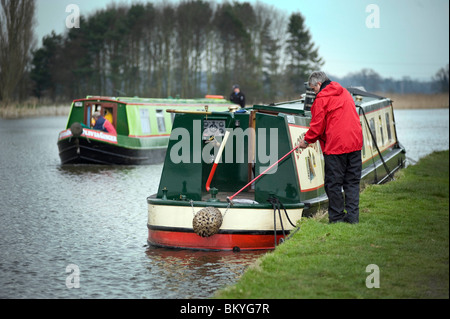 Mann festmachen Kanalboot schmale Bank Stockfoto