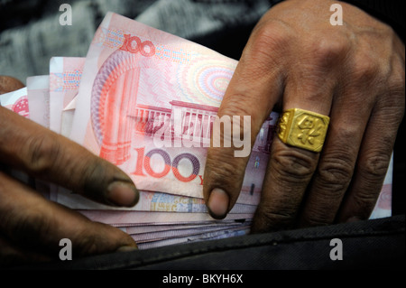 Ein chinesischer Anbieter Überprüfung Renminbi Anmerkungen auf dem Großmarkt in Peking, China. 12. Mai 2010 Stockfoto