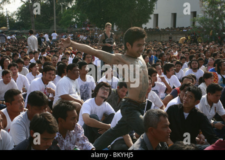 Ein Mann in Trance Wai Kru tagsüber am Wat Bang Phra, ein buddhistischer Tempel in Thailand, wo Mönche Anhänger tattoo. Stockfoto