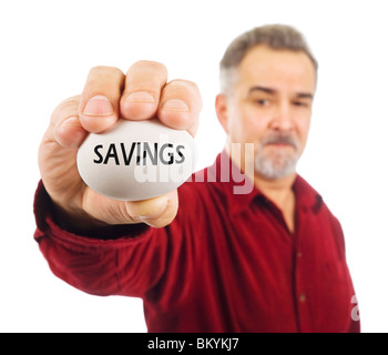 Mann hält weißes Ei mit Einsparungen geschrieben steht, als Symbol für die Zerbrechlichkeit von Geldangelegenheiten; die sprichwörtliche "Notgroschen". Stockfoto