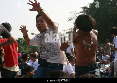 Ein Mann in Trance Wai Kru tagsüber am Wat Bang Phra, ein buddhistischer Tempel in Thailand, wo Mönche Anhänger tattoo. Stockfoto