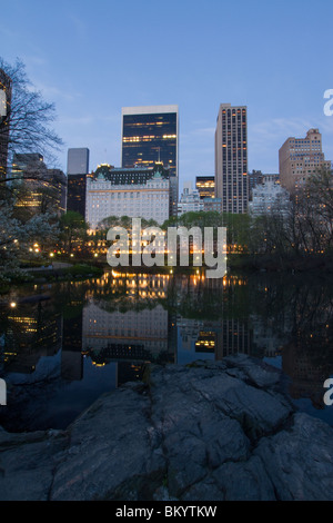 Das Plaza Hotel und die Skyline von Manhattan gesehen von der Gapstow-Brücke im Central Park in der Morgendämmerung. Stockfoto