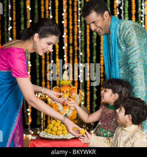 Frau, die ihre Kinder an Diwali Süßigkeiten geben Stockfoto