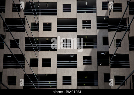 Quadratische Motiv in der Fassadengestaltung der Balkon mit Geländer in mehrstöckigen Gebäudes spiegelt sich in Glas auf beiden Seiten. Stockfoto