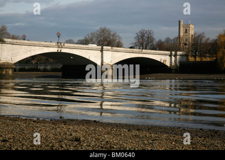 Blick über den Fluss Themse Putney Bridge und All Saints Church, Fulham, London, Großbritannien Stockfoto