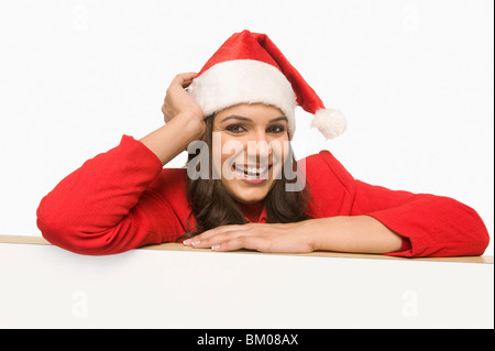 Frau in Santa Kostüm beugte sich über ein Whiteboard und lächelnd Stockfoto