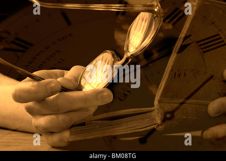 Eine Hand hält ein paar Brillen, eine alte Bibel lesen Stockfoto