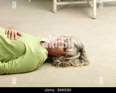 Reife schwangere Frau am Boden liegend Stockfoto