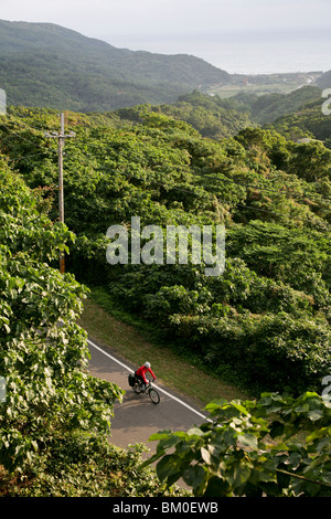 Radfahrer auf einer Straße durch Regenwald, Ostküste von Taiwan, Republik China, Taiwan, Asien Stockfoto