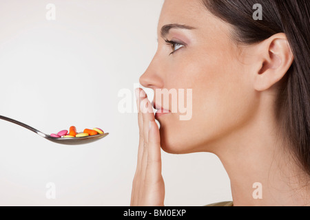 Nahaufnahme einer Frau mit einem Löffel von Pillen Stockfoto