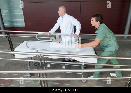 Arzt mit einem Krankenpfleger Drücken einer Bahre Stockfoto