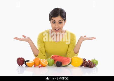 Frau mit verschiedenen frischen Früchten und Gestikulieren Stockfoto