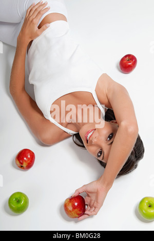 Erhöhte Ansicht einer Frau liegend mit roten und grünen Äpfeln Stockfoto