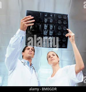 Arzt und eine Krankenschwester untersuchen einen Röntgen-Bericht Stockfoto