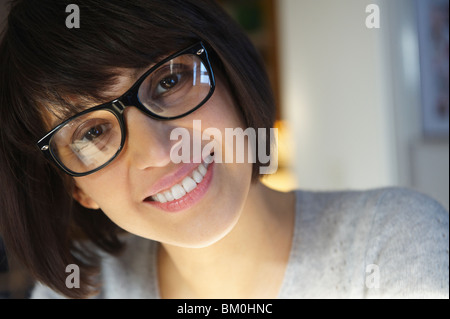 Frau mit Brille, lächelnd in die Kamera Stockfoto