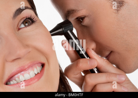 Überprüfung eines Weibes Ohr mit einem Otoskop Arzt Stockfoto