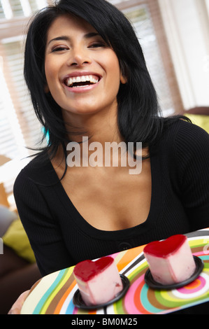 Frau halten zwei herzförmige Kuchen Stockfoto