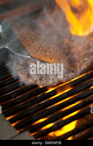 Einen geflammte Beef-Burger auf dem Grill Kochen Stockfoto