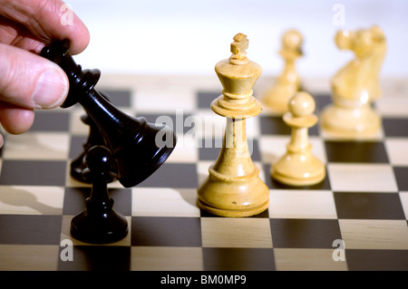 Schach. Schwarz bewegt sich die Königin Schachfiguren auf Schachbrett, Königin in der hand Stockfoto