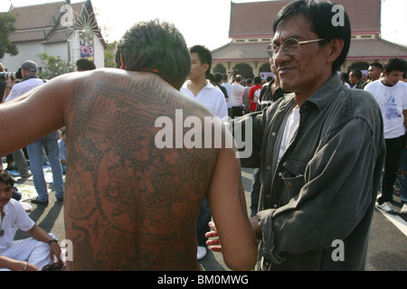 tätowierte Mann Wai Kru tagsüber am Wat Bang Phra, ein buddhistischer Tempel in Thailand, wo Mönche Anhänger tattoo. Stockfoto