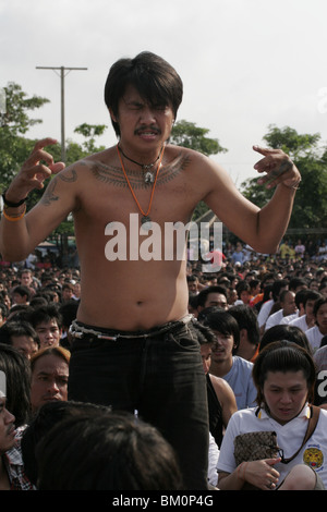 Ein Mann in Trance Wai Kru tagsüber am Wat Bang Phra, ein buddhistischer Tempel in Thailand, wo Mönche Anhänger tattoo. Stockfoto