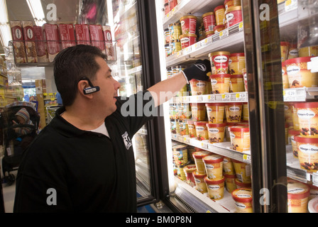 Mitarbeiter der Håågen-Dazs Eis Lager einen Gefrierschrank in einem Supermarkt in New York Stockfoto