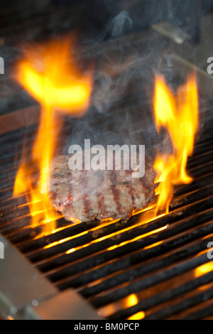 Einen geflammte Beef-Burger auf dem Grill Kochen Stockfoto