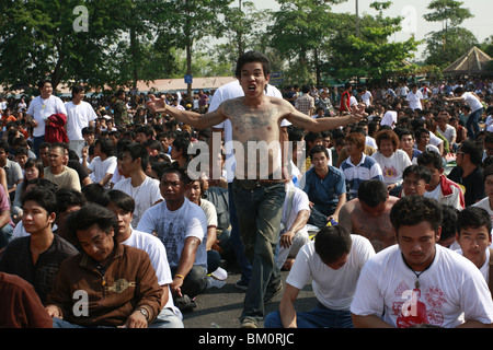 Ein Mann in Trance Wai Kru tagsüber am Wat Bang Phra, ein buddhistischer Tempel in Thailand, wo Mönche Anhänger tattoo. Stockfoto