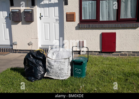 Normalen schwarzen Auffangbeutel, Kunststoff-Sammelbehälter und Essen Abfallbehälter außerhalb Residenz in Hounslow Middx, UK. Stockfoto