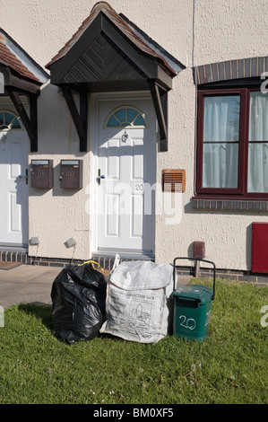 Normalen schwarzen Auffangbeutel, Kunststoff-Sammelbehälter und Essen Abfallbehälter außerhalb Residenz in Hounslow Middx, UK. Stockfoto