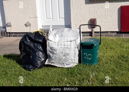 Normalen schwarzen Auffangbeutel, Kunststoff-Sammelbehälter und Essen Abfallbehälter außerhalb Residenz in Hounslow Middx, UK. Stockfoto