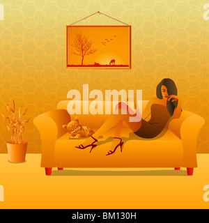 Frau sitzt auf einer Couch mit ihrer Katze Stockfoto