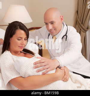 Arzt mit einer Frau mit ihrem Neugeborenen Baby in einem Krankenhaus Stockfoto