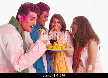 Freunde Essen Laddu auf Holi Stockfoto