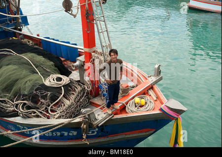 Ein Thai Fischer lächelt aus dem Bogen von seinem Fischerboot auf der Insel Koh Samui in Thailand Stockfoto