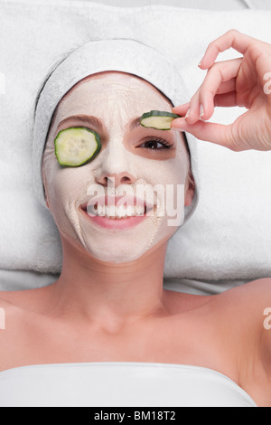 Gurkenscheiben auf die Augen einer Frau Stockfoto
