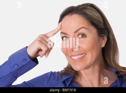 Frau zeigt auf ihrem Tempel Stockfoto