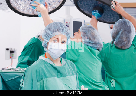 Ärzte, die Anpassung einer OP Lampe in einem OP-Saal Stockfoto