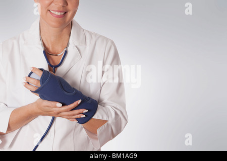 Ärztin, die das Tragen einer Handgelenkbandage Stockfoto