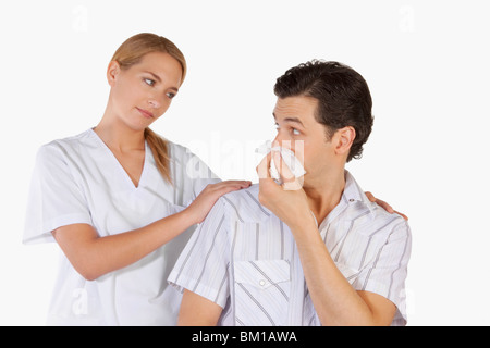 Frau neben einem Mann leidet unter Kälte Stockfoto