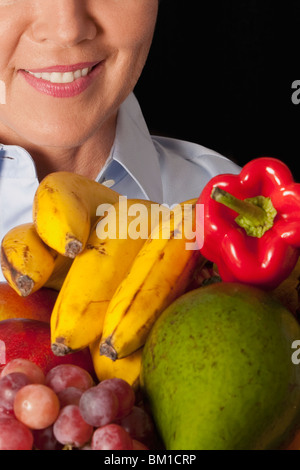 Frau mit verschiedenen Früchten Stockfoto