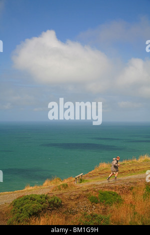 Einsame männliche Walker auf Constitution Hill, Aberystwyth mit Cardigan Bay hinter Ceredigion, Wales, UK Stockfoto