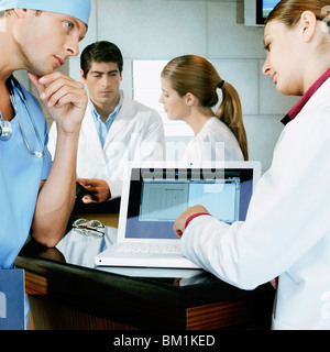 Ärztin und einem Chirurgen diskutieren ein medizinisches Gutachten auf einem laptop Stockfoto