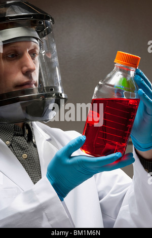 Arzt hält eine Flasche Lösung in einem Labor Stockfoto