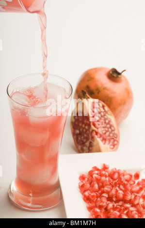 Nahaufnahme der Granatapfel mit einem Glas Granatapfelsaft Stockfoto