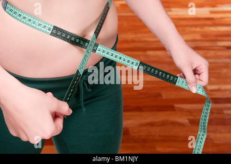 Frau, die ihre Taille mit einem Maßband messen Stockfoto