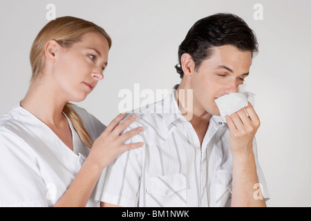 Frau neben einem Mann leidet unter Kälte Stockfoto