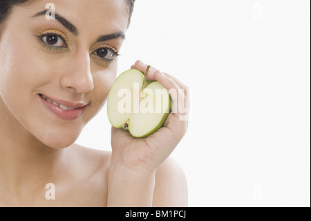 Porträt einer Frau mit einer Hälfte des grünen Apfel Stockfoto